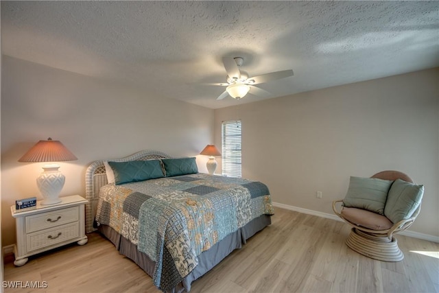 bedroom with a textured ceiling, ceiling fan, and light hardwood / wood-style flooring