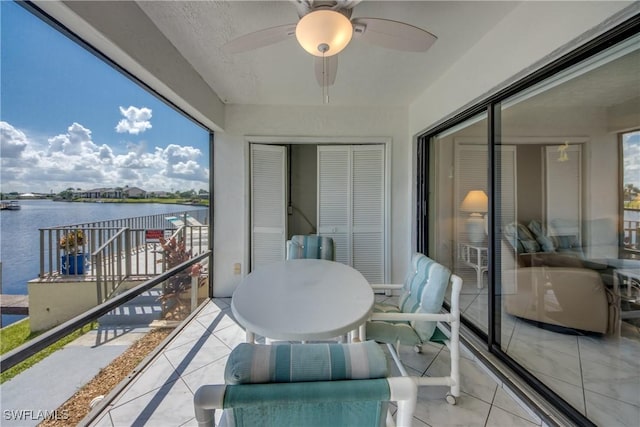 balcony with ceiling fan and a water view