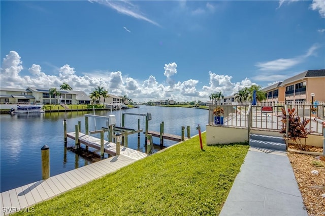 view of dock featuring a lawn and a water view