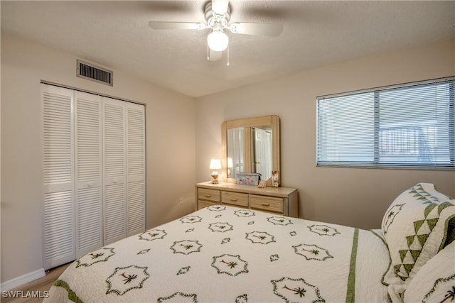 bedroom with a closet, ceiling fan, and a textured ceiling