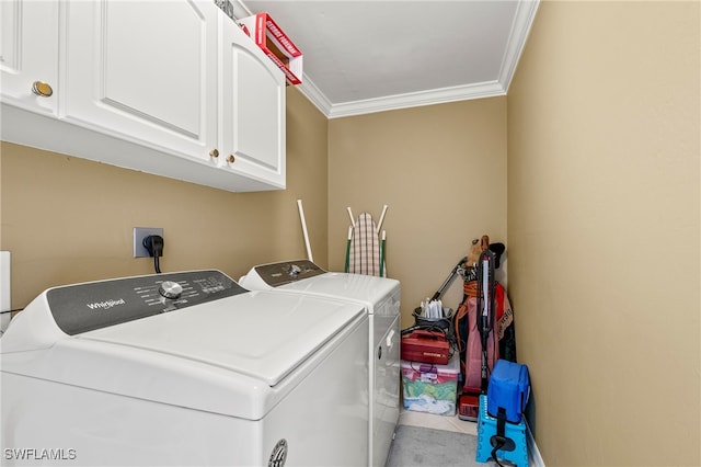 washroom featuring ornamental molding, cabinets, and washer and dryer