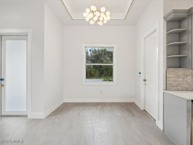 unfurnished dining area featuring built in features and a notable chandelier