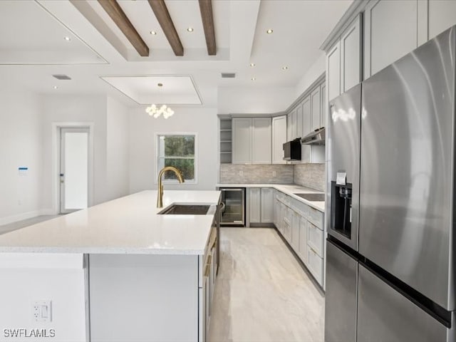 kitchen featuring sink, beverage cooler, backsplash, stainless steel fridge with ice dispenser, and gray cabinets