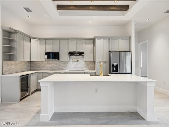 kitchen with gray cabinetry, wine cooler, stainless steel appliances, and tasteful backsplash