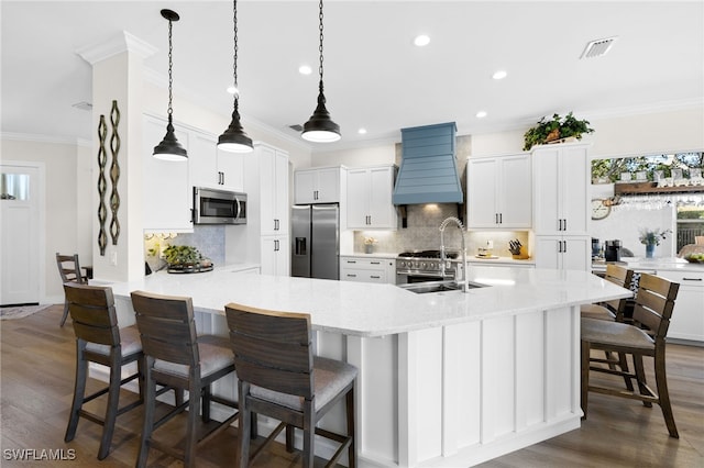 kitchen featuring white cabinets, appliances with stainless steel finishes, dark hardwood / wood-style floors, custom range hood, and a kitchen breakfast bar