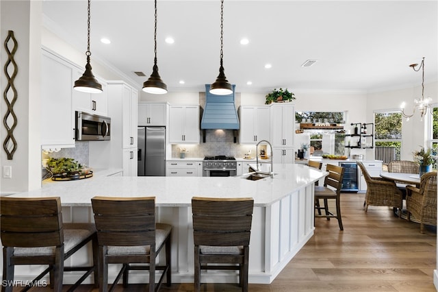 3684 Sudbury Ln, Bonita Springs, FL 34134 - kitchen with stainless steel appliances, premium range hood, white cabinetry, a breakfast bar, and backsplash