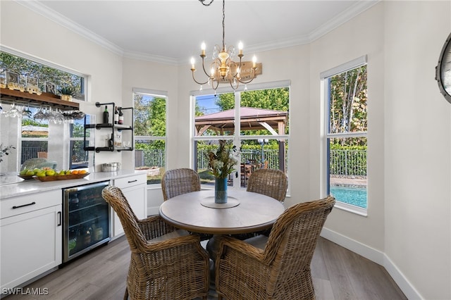 3684 Sudbury Ln, Bonita Springs, FL 34134 - dining room featuring wine cooler, a chandelier, a dry bar, plenty of natural light, and crown molding