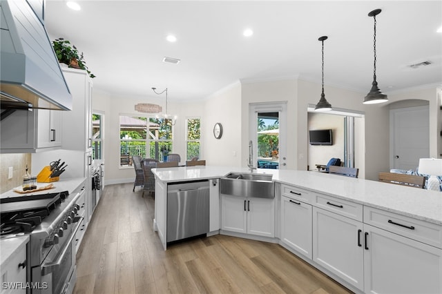 kitchen featuring light hardwood / wood-style floors, white cabinetry, hanging light fixtures, custom range hood, and appliances with stainless steel finishes