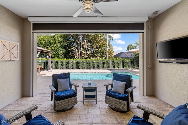 view of patio / terrace with ceiling fan and a fenced in pool