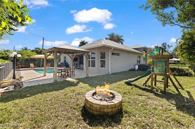 3684 Sudbury Ln, Bonita Springs, FL 34134 - back of property featuring a gazebo, a fire pit, a playground, a fenced backyard, and a patio area