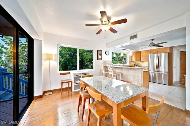 dining area featuring ceiling fan, light hardwood / wood-style flooring, and sink