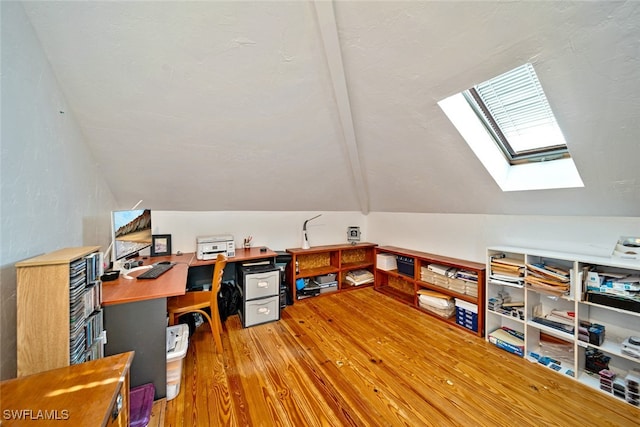 home office with wood-type flooring and lofted ceiling with skylight