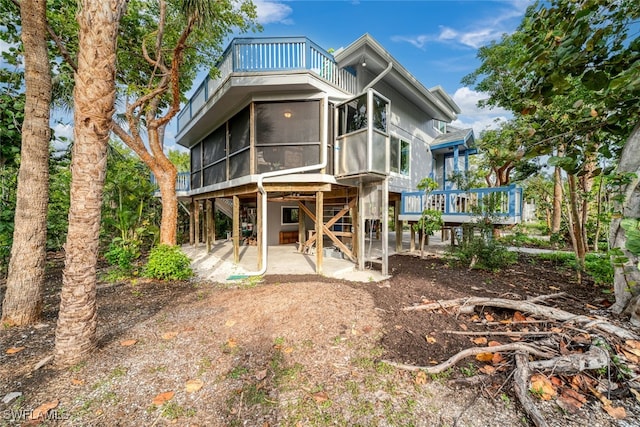 back of property featuring a sunroom and a patio