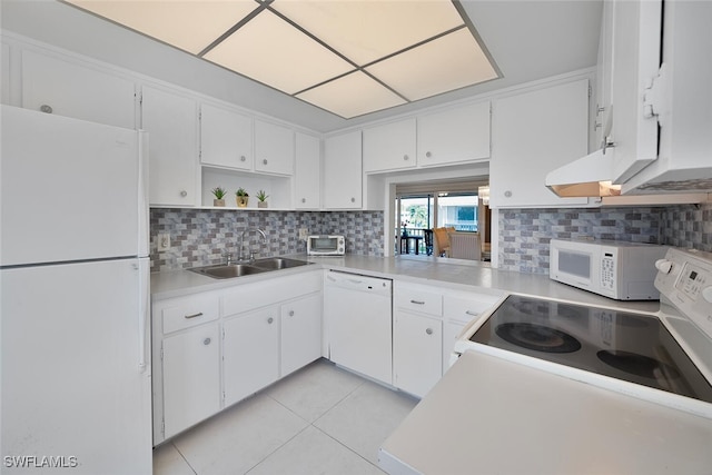 kitchen featuring white appliances, white cabinetry, light tile patterned floors, and sink