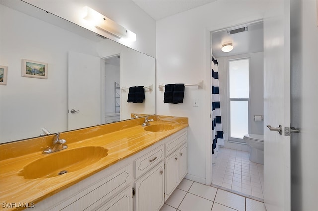 bathroom featuring vanity, tile patterned flooring, toilet, and curtained shower