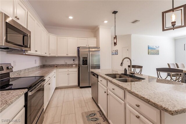 kitchen featuring stainless steel appliances, hanging light fixtures, a kitchen island with sink, and sink