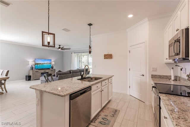 kitchen featuring white cabinets, a center island with sink, stainless steel appliances, and hanging light fixtures