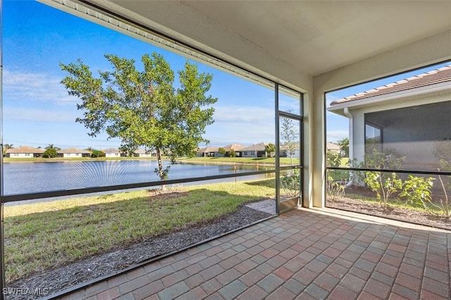 unfurnished sunroom featuring a water view