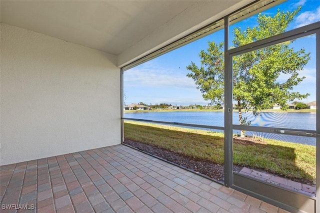 unfurnished sunroom featuring a water view