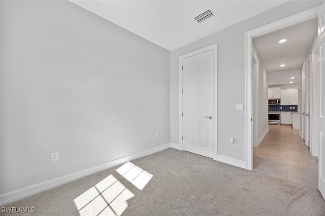 unfurnished bedroom with light colored carpet