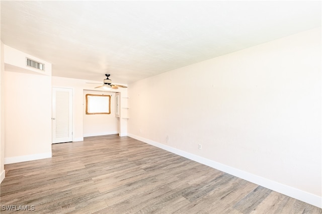 empty room with ceiling fan and light wood-type flooring