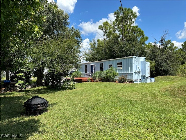 view of yard featuring a deck and an outdoor fire pit