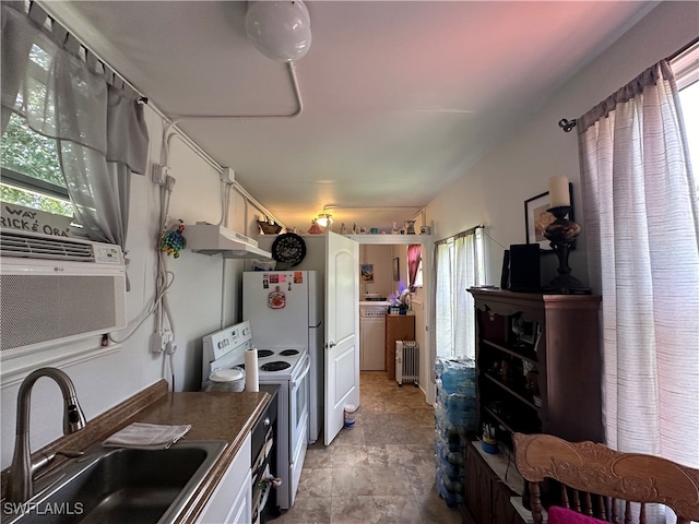 kitchen with white electric stove, sink, and white cabinets