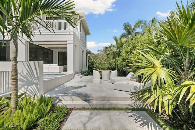 exterior space with a balcony, a swimming pool, and a patio area