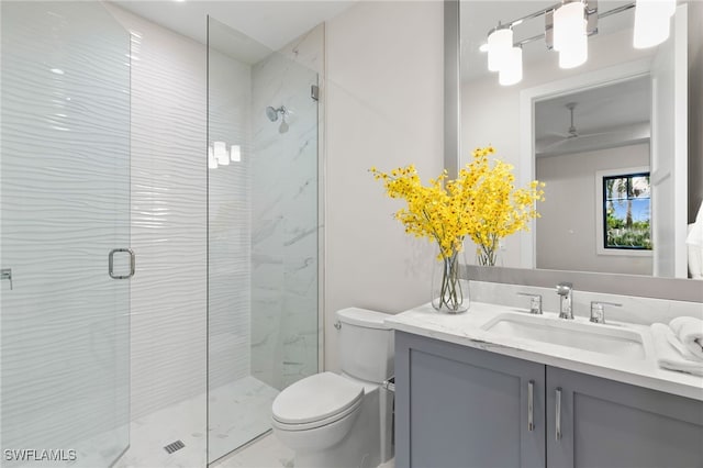 full bathroom with vanity, a ceiling fan, toilet, and a stall shower