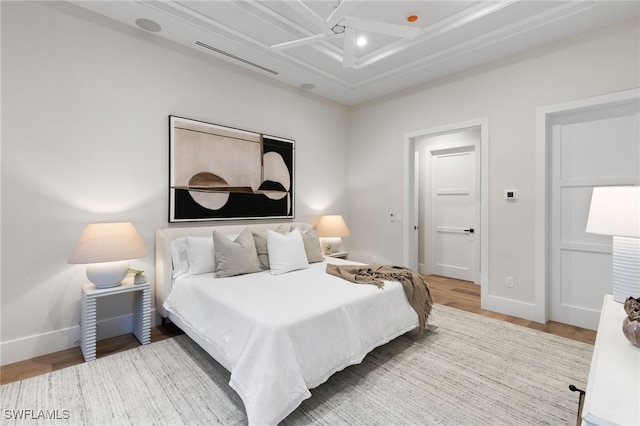 bedroom featuring baseboards, wood finished floors, and visible vents