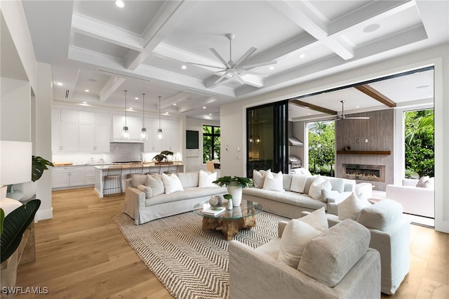 living room with light hardwood / wood-style floors, beamed ceiling, coffered ceiling, and ceiling fan