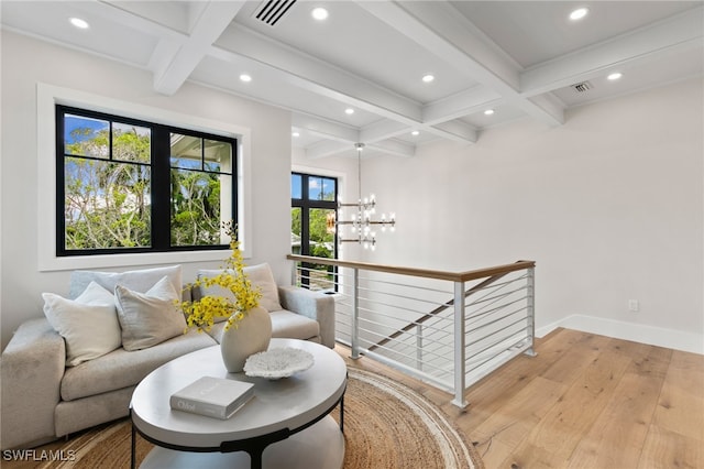 living area with beamed ceiling, light wood-style floors, an upstairs landing, and coffered ceiling