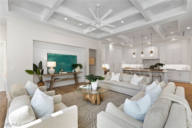 living room featuring beamed ceiling, coffered ceiling, and light wood finished floors