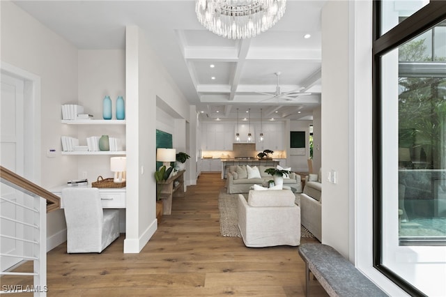 living area featuring beam ceiling, ceiling fan with notable chandelier, recessed lighting, light wood-type flooring, and coffered ceiling
