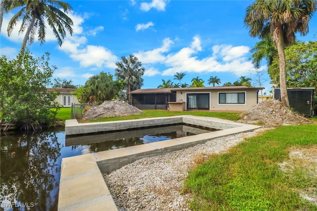 view of dock with a yard and a water view