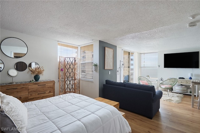 bedroom with a textured ceiling and hardwood / wood-style flooring