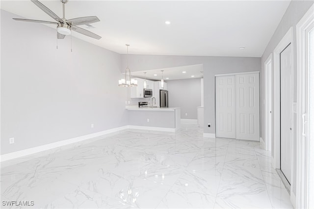 unfurnished living room with vaulted ceiling, ceiling fan with notable chandelier, and sink