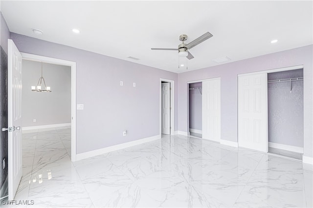 unfurnished bedroom featuring ceiling fan with notable chandelier and multiple closets