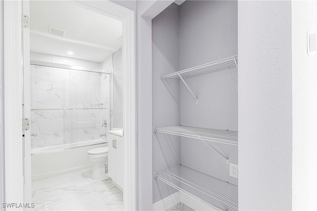 interior space featuring toilet and tiled shower / bath combo