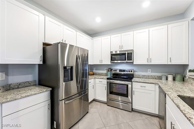 kitchen featuring light stone countertops, appliances with stainless steel finishes, and white cabinetry