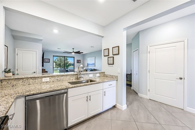 kitchen featuring dishwasher, light stone counters, sink, white cabinetry, and light tile patterned floors