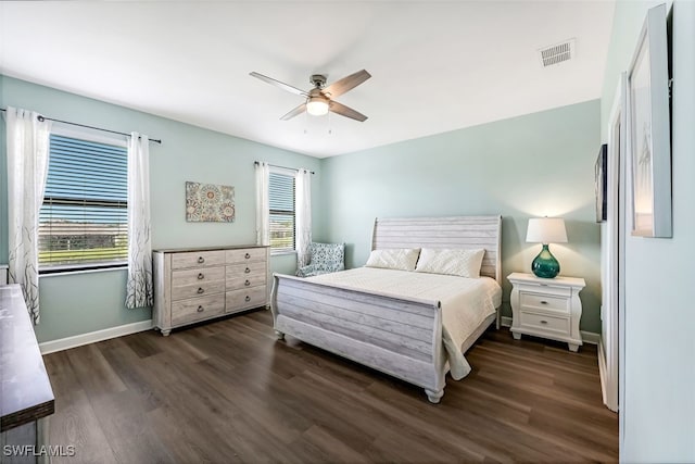 bedroom with multiple windows, dark hardwood / wood-style floors, and ceiling fan