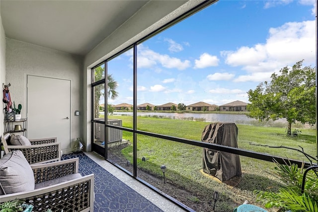 sunroom featuring a water view