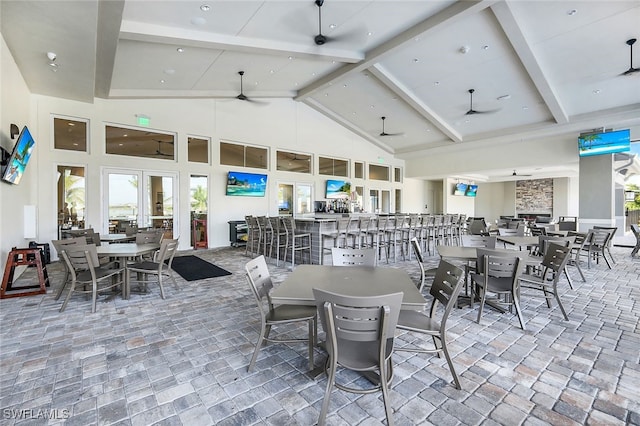 dining room with high vaulted ceiling, beam ceiling, and ceiling fan