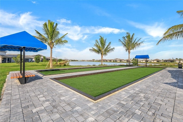 view of property's community with a water view and a yard