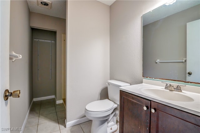 bathroom with a textured ceiling, tile patterned flooring, vanity, and toilet