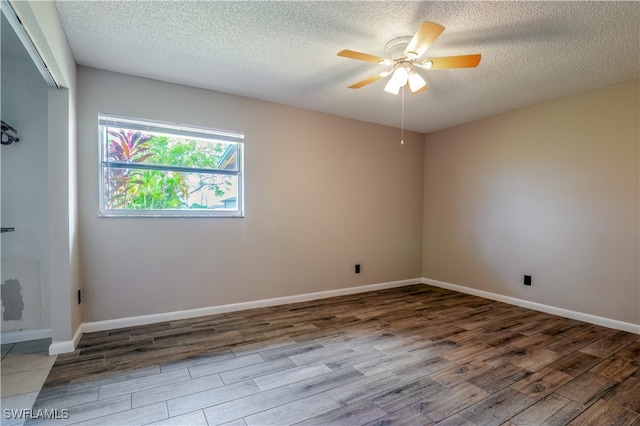 spare room with light wood-type flooring, ceiling fan, and a textured ceiling