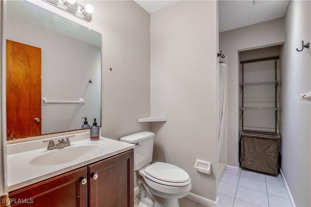 bathroom with tile patterned flooring, a textured ceiling, walk in shower, vanity, and toilet