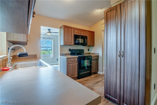 kitchen featuring ceiling fan, sink, a textured ceiling, light hardwood / wood-style flooring, and black appliances