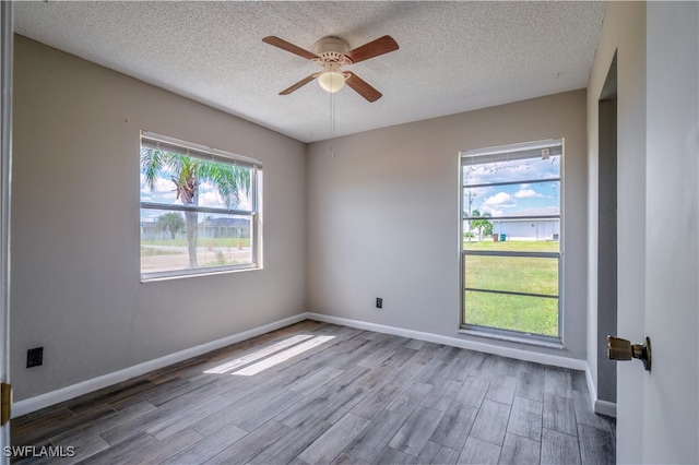 spare room with a textured ceiling, wood-type flooring, and ceiling fan